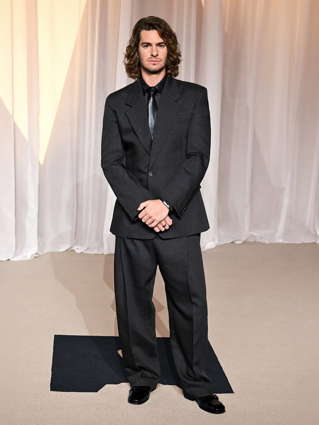 Andrew Garfield chooses custom Ferragamo for the Academy Awards. In Los Angeles for the occasion, he was seen in a black and espresso wool-linen suit, paired with a leather-detailed shirt and tie. Styled by Warren Alf…